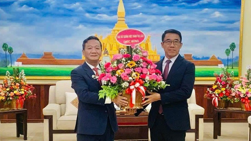 El embajador de Vietnam en Laos, Nguyen Minh Tam, entrega flores del secretario general del PCV, To Lam, al jefe interino de la Comisión de Relaciones Exteriores del Comité Central del PPRL, Bounleua Phandanouvong, con motivo del 70 aniversario de la fundación del PPRL. (Fotografía: Nhan Dan)