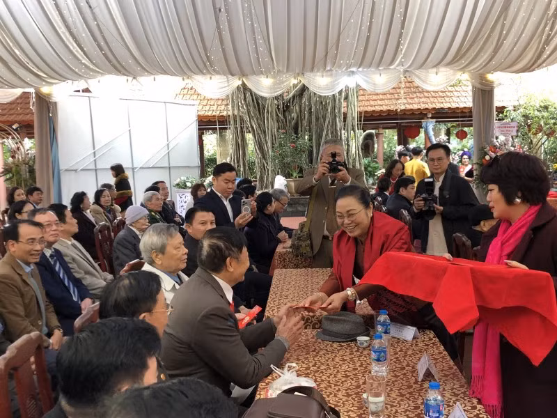 La embajadora Khamphao Eunthavanh da dinero de suerte a los invitados, una costumbre de los vietnamitas.