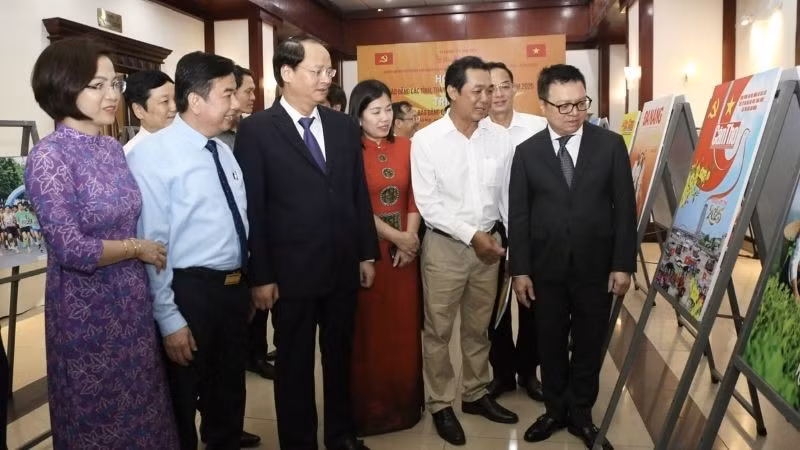 Los delegados visitan una exposición fotográfica al margen de la conferencia. (Fotografía: Nhan Dan)