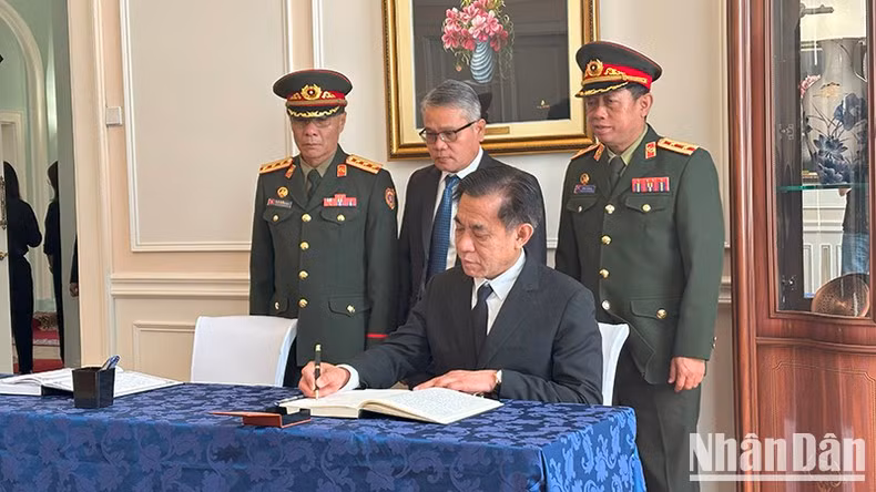 Un representante de la Embajada de Laos en Rusia firma el libro de condolencias.