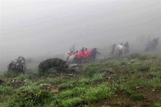 Los rescatistas trasladan cuerpos de las víctimas al lugar del accidente aéreo. (Fotografía: AFP/VNA)