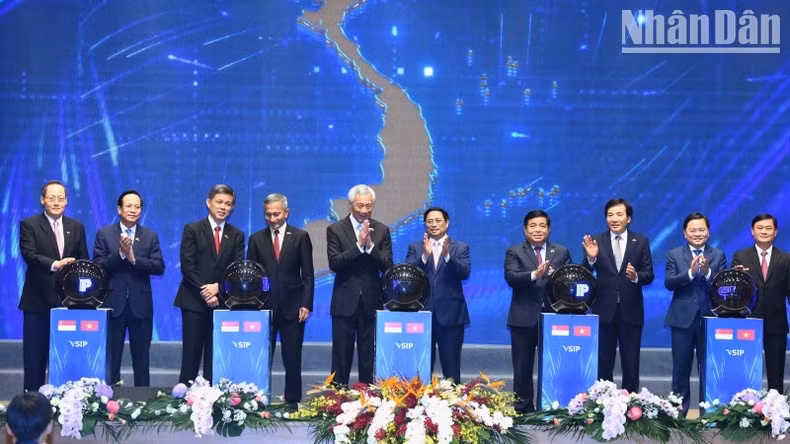 Los dos primeros ministros presencian la puesta en marcha de varios proyectos de VSIP. (Fotografía: Nhan Dan)