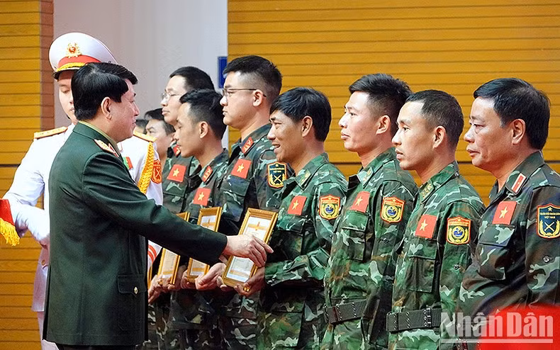El general Luong Cuong entrega el Certificado de Reconocimiento del Ministro de Defensa a las personas sobresalientes en el despliegue de dicha labor solidaria.
