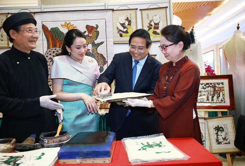 El primer ministro de Vietnam, Pham Minh Chinh, y su homóloga tailandesa, Paetongtarn Shinawatra, contemplan productos artesanales vietnamitas. (Fotografía: VNA)