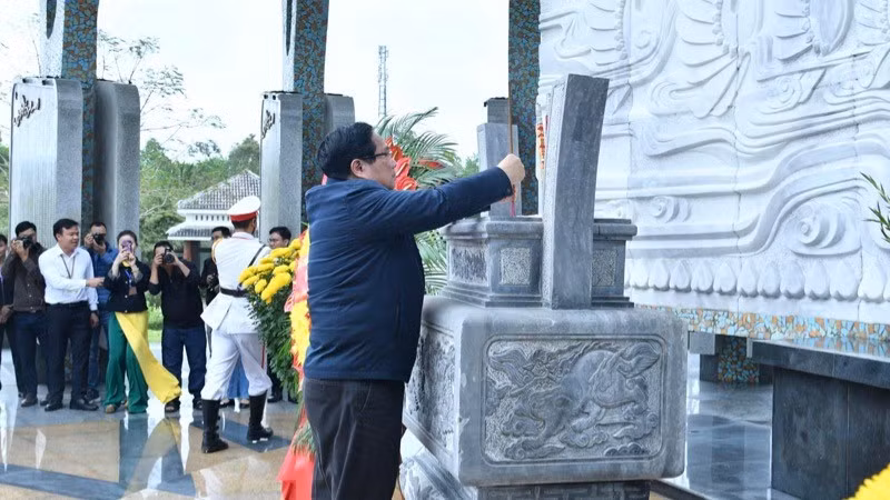 Minh Chinh coloca inciensos en el Monumento a los Héroes y Mártires de guerra en el cementerio.