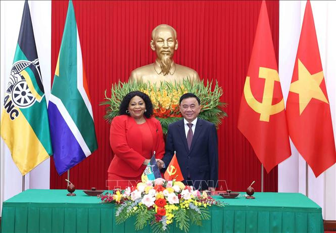 El miembro del Buró Político y permanente del Secretariado del Comité Central del PCV, Tran Cam Tu, y la vicesecretaria general del ANC de Sudáfrica, Nomvula Mokonyane, intercambian un documento de cooperación entre los dos Partidos. (Fotografía: VNA)