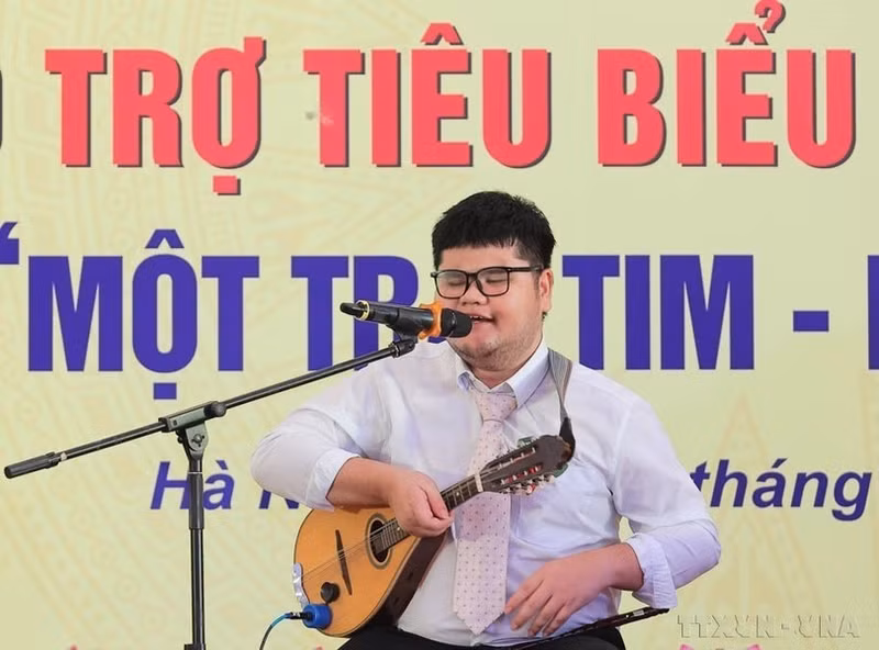 Bui Ngoc Thinh, una persona con discapacidad visual de la provincia de Khanh Hoa que domina 14 instrumentos musicales y ha ganado numerosos premios, habla en una conferencia en homenaje a los discapacitados, huérfanos y benefactores destacados del país, en el marco de la cual también se desarrolló el programa "Un corazón-Un Mundo".