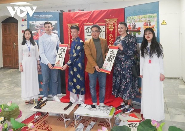 Estudiantes vietnamitas presentan obras de caligrafía tradicional a amigos extranjeros. (Fotografía: VOV)