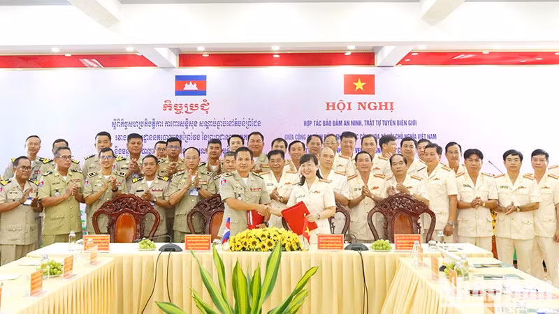 Los dos cuerpos policiales firman un documento de cooperación en la conferencia. (Fotografía: Nhan Dan)