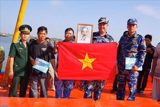 La guardacostas de Ba Ria-Vung Tau regala la bandera nacional a pescadores locales. (Fotografía: VNA)