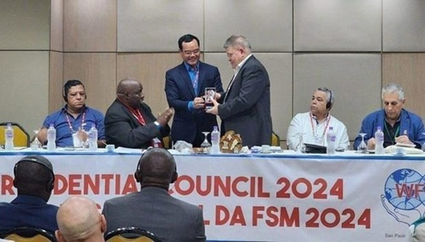 En el evento, el presidente de la Confederación General del Trabajo de Vietnam, Nguyen Dinh Khang, entrega un recuerdo a la junta directiva de la Federación Sindical Mundial. (Fotografía: VNA)