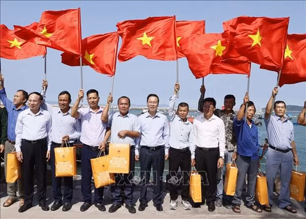 El presidente Vo Van Thuong entrega la bandera nacional a los pescadores del distrito insular de Co To, provincia de Quang Ninh. (Fotografía: VNA)
