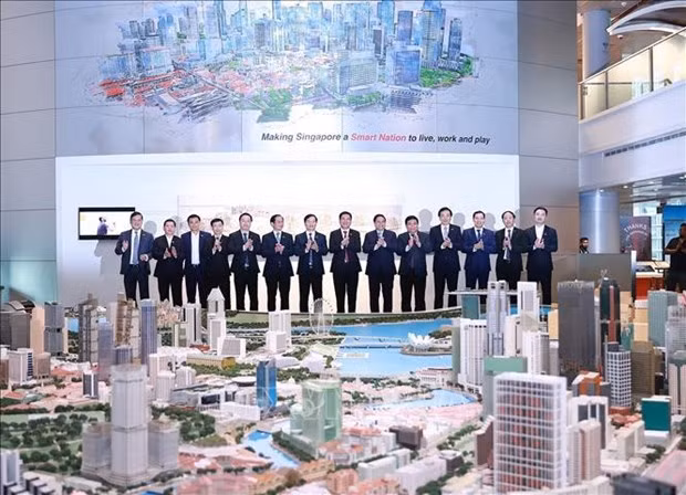 El primer ministro de Vietnam, Pham Minh Chinh, y los delegados visitan una exposición sobre la planificación inteligente de Singapur. (Fotografía: VNA)