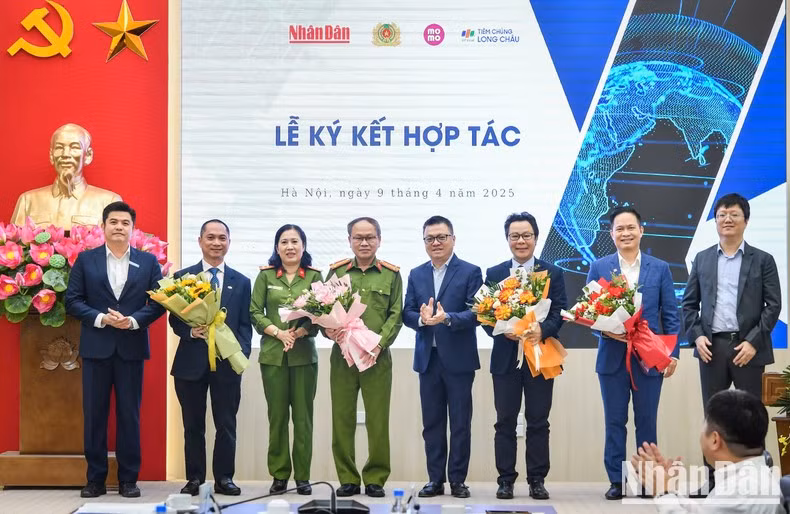 El presidente-editor de Nhan Dan, Le Quoc Minh, entrega flores a los delegados.