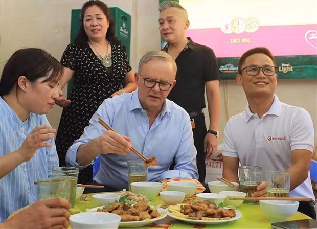 El primer ministro de Australia, Anthony Albanese, disfruta del cerdo asado vietnamita. (Fotografía: VNA)
