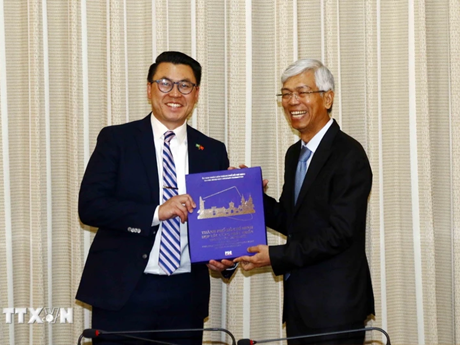 El vicepresidente del Comité Popular de Ciudad Ho Chi Minh, Vo Van Hoan, regala un libro de relaciones exteriores al senador Joseph Nguyen (Fuente: VNA)
