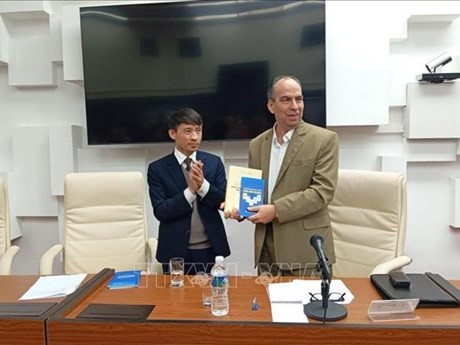 Vo Van Be, subdirector y subeditor en jefe de la Editorial Política Nacional Su That, regala el libro a Rogelio Polanco Fuentes, jefe del Departamento Ideológico en el Comité Central del Partido Comunista de Cuba. (Fuente:VNA)