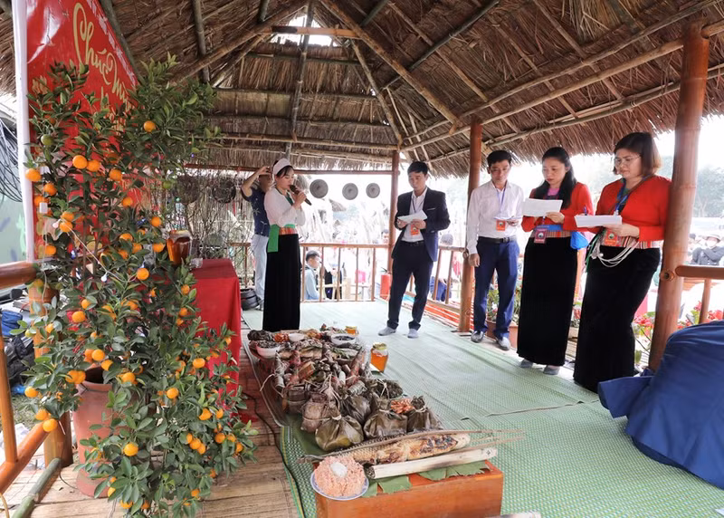 El jurado califica las bandejas de comidas tradicionales de los Muong en el festival. (Foto: VNA)