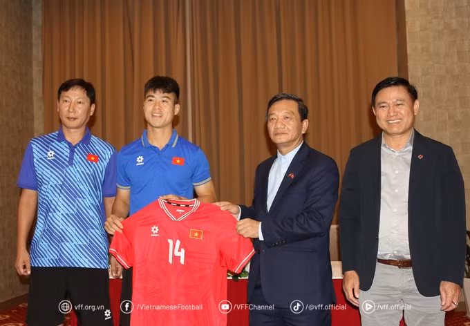 El director de la selección de fútbol de Vietnam, Tran Anh Tu, el entrenador Kim Sang Sik, y el capitán Do Duy Manh entregan una camiseta de recuerdo al embajador Nguyen Minh Tam.