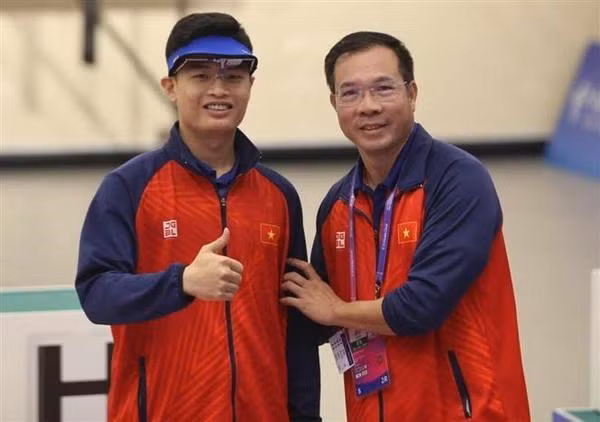 El tirador Pham Quang Huy y su entrenador Hoang Xuan Vinh (Foto: VNA)