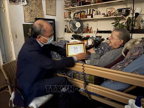 El embajador Dinh Toan Thang obsequia un logotipo que simboliza el 50 aniversario de Vietnam y Francia (Foto: VNA)