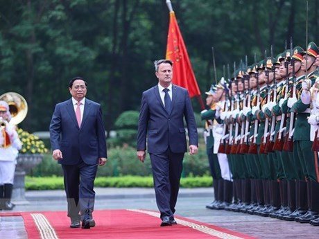 El primer ministro Pham Minh Chinh (izquierda) y su homólogo luxemburgués Xavier Bettel revisan la guardia de honor. (Foto: VNA)