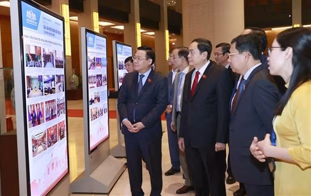 El presidente de la Asamblea Nacional de Vietnam, Vuong Dinh Hue, y los delegados visitan la Exhibición sobre Improntas de las actividades de relaciones exteriores del Parlamento. (Foto: VNA)