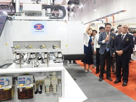 Dirigentes del Ministerio de Agricultura y Desarrollo Rural de Vietnam y representantes empresariales participan en un pabellón de exhibición de maquinarias y tecnologías de la industria de madera en la Feria (Foto: VNA)