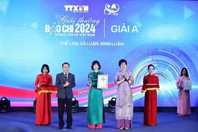 Nguyen Duc Loi, vicepresidente permanente de la Asociación de Periodistas de Vietnam y Vu Viet Trang, directora general de la Agencia de Noticias de Vietnam, entregaron el premio A al autor. (Fuente: VNA)