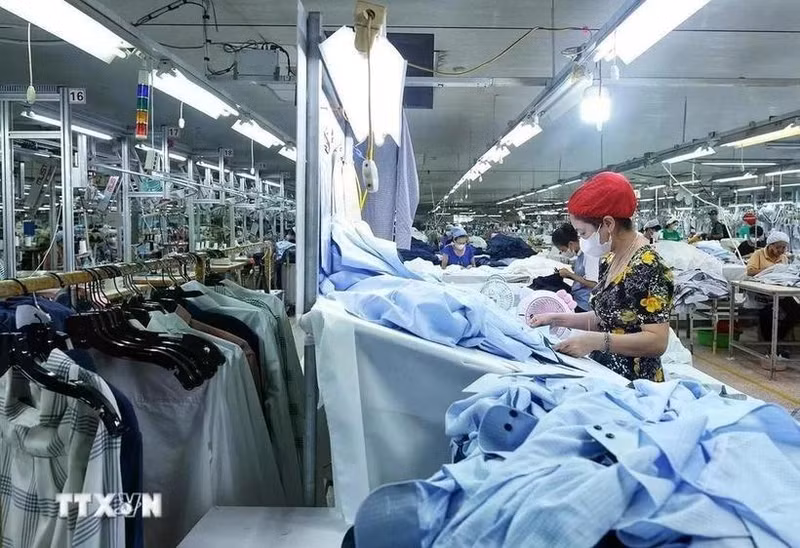 Los trabajadores confeccionan prendas de vestir para la exportación. (Foto: VNA)