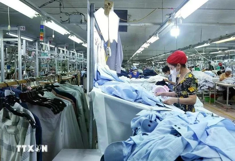 Los trabajadores confeccionan prendas de vestir para la exportación. (Foto: VNA)