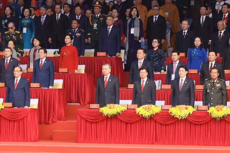 Dirigentes del Partido Comunista y Estado, y los invitados internacionales asisten a la ceremonia de izamiento de la bandera de Vietnam.