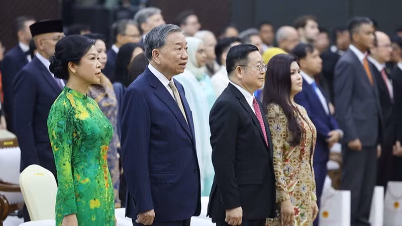 El máximo dirigente partidista de Vietnam, To Lam, y su esposa, y el secretario general de la Asean, Kao Kim Hourn y su cónyuge realizan el acto de saludo a la bandera de la Asean.
