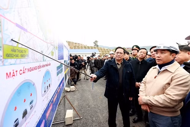 El primer ministro vietnamita, Pham Minh Chinh, y los gestores y obreros participantes en la construcción del ramo de la autopista Mai Son - la Ruta Nacional 45. (Fotografía: VNA)