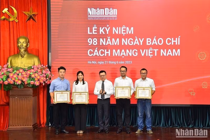El director-editor del diario, Le Quoc Minh, entrega certificado de mérito a los individuos destados en 2022.