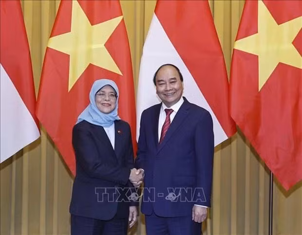 El presidente de Vietnam, Nguyen Xuan Phuc, recibe a su homóloga de Singapur, Halimah Yacob. (Fotografía: VNA)