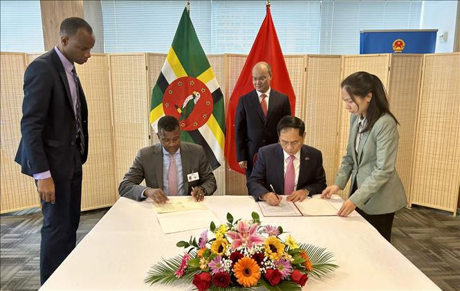 El canciller vietnamita, Bui Thanh Son, y el ministro de Relaciones Exteriores, Negocios Internacionales, Comercio y Energía de la Mancomunidad de Dominica, Vince Henderson, firman un acuerdo de exención de visa para titulares de pasaportes diplomáticos y oficiales. (Fotografía: VNA)