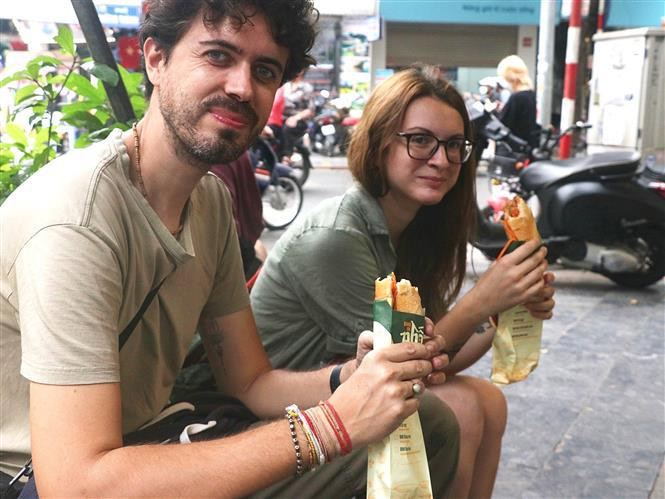 Los turistas disfrutan del banh mi de Vietnam. (Fotografía: VNA)