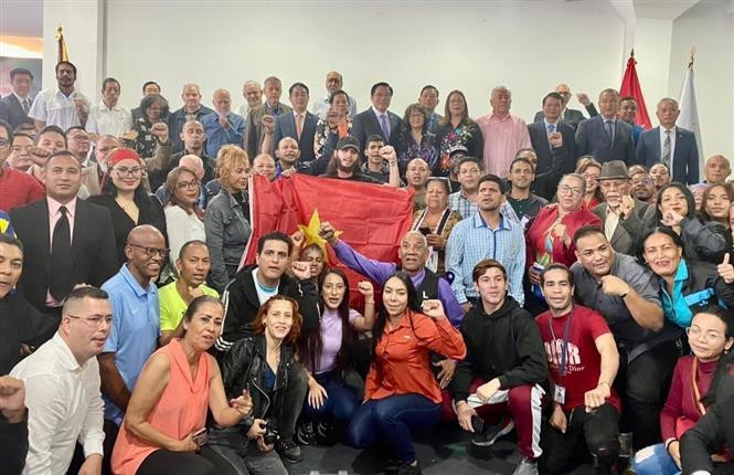 El miembro del Buró Político, secretario del Comité Central del PCV y jefe de la Comisión de Asuntos Internos, Phan Dinh Trac, con profesores, estudiantes y representantes venezolanos. (Fotografía: VNA)