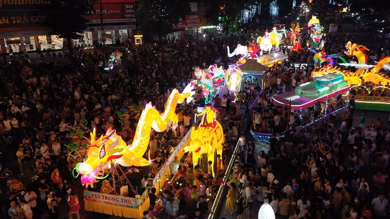 La gente desfila con gigantes linternas de diferentes colores y tamaños por las calles de Tuyen Quang.