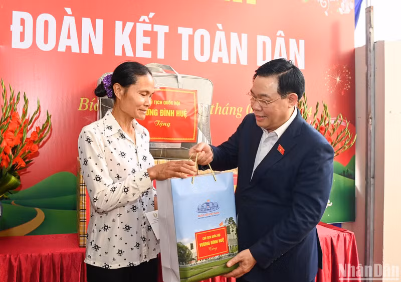 Vuong Dinh Hue entrega regalos a la delegada Le Thi Chinh.