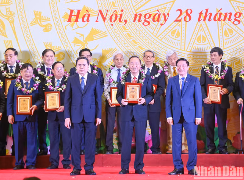 El presidente de la AN, Tran Thanh Man, y el secretario general y presidente de la Oficina del órgano legislativo, Bui Van Cuong, entregan logotipos y flores a destacados intelectuales del sector científico y tecnológico en 2024.