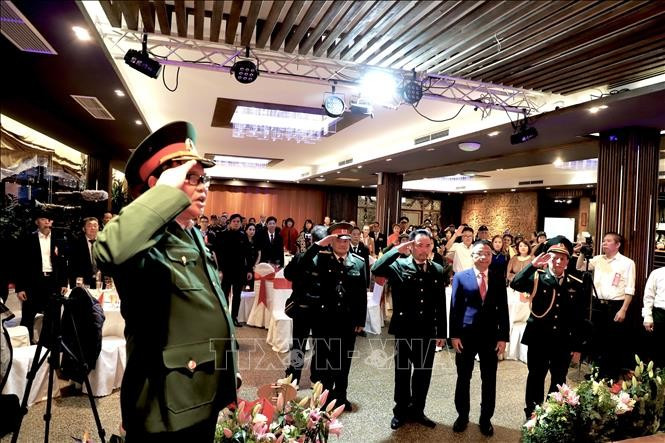 La Asociación de Veteranos de Vietnam en Berlín-Brandeburgo realiza la ceremonia de izamiento de la bandera en el acto conmemorativo al 80 aniversario de la fundación del Ejército Popular de Vietnam. (Foto: VNA)