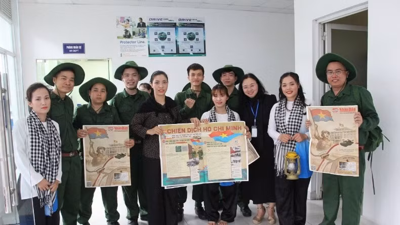 Jóvenes trabajadores de la empresa de responsabilidad limitada Cedo Vietnam reciben con alegría la publicación informativa especial de Nhan Dan tras finalizar una actuación artística.