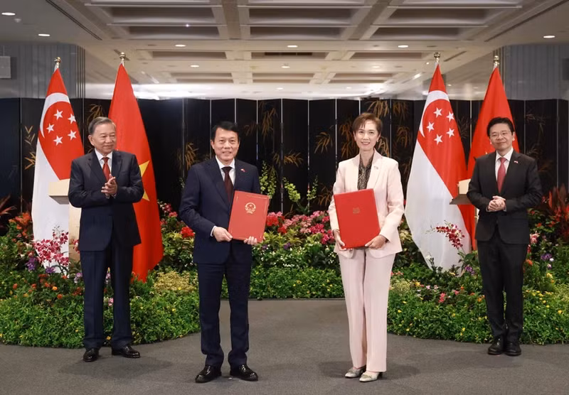 El secretario general To Lam (primero a la izquerda), y el primer ministro Lawrence Wong (primero a la derecha), presencian el intercambio de un memorando de entendimiento sobre transformación digital entre el Ministerio de Seguridad Pública de Vietnam y el Ministerio de Desarrollo Digital e Información de Singapur. (Foto: VNA)