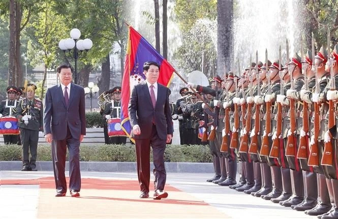 El presidente de Vietnam, Luong Cuong (derecha), y el secretario general del Comité Central del Partido Popular Revolucionario Lao (PLRP) y presidente de Laos, Thongloun Sisoulith, pasan revista a la guardia de honor en la ceremonia de bienvenida. (Foto: VNA)