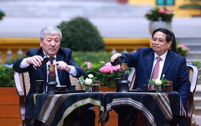 El primer ministro vietnamita, Pham Minh Chinh, presenta al premier Adylbek Kasymaliev la cultura del café en Vietnam. (Foto: VNA)
