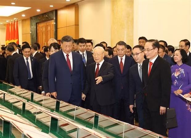 Nguyen Phu Trong y Xi Jinping escuchan la presentación de los documentos de cooperación firmados entre los dos países. (Foto: VNA)