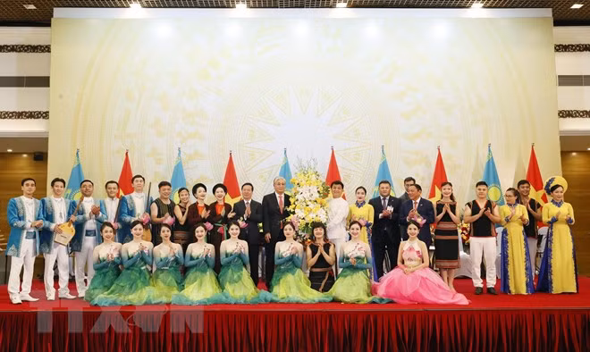 El presidente vietnamita, Vo Van Thuong, y su homólogo kazajo, Kassym-Jomart Tokayev, entregan flores a los artistas que actúan en el banquete. (Foto: VNA)