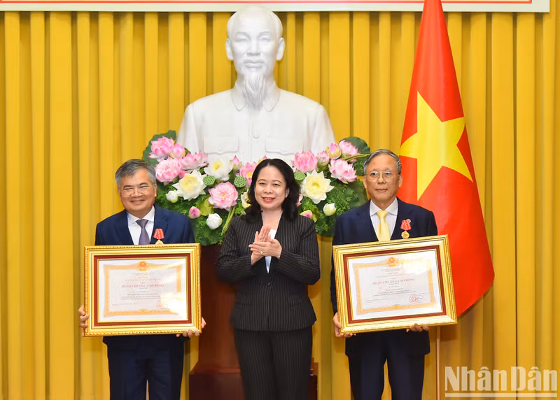 La vicepresidenta Vo Thi Anh Xuan entrega la Medalla de Trabajo de Primera Clase al camarada Bui Huy Hung (derecha) y la Medalla de Trabajo de Segunda Clase al camarada Can Dinh Tai (izquierda).